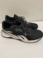 Left side view of both sneakers showing mesh upper, vector accents, outsole