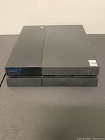 Front and top view of PlayStation 4 console showing overall condition