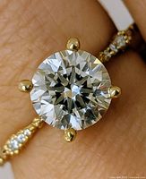 Close-up of round brilliant center diamond in prong setting