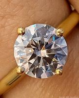 Close-up of ring on finger, showing stone and prongs