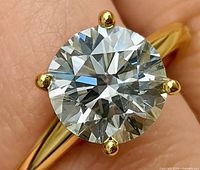 Close-up of round lab diamond in yellow gold prongs
