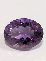 Front view of oval faceted purple amethyst gemstone