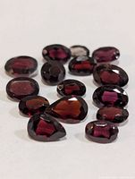 Group of faceted garnet stones showing color and cuts