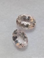 Two loose oval morganite gemstones close-up on white background