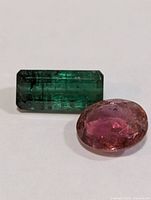 Green rectangular and pink oval tourmaline gemstones close-up