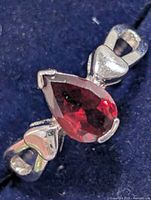 Front view of ring showing pear-cut garnet and heart motifs