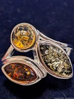 Front view of sterling silver ring showing three amber cabochons