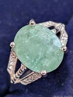 Oblique view of ring showing gemstone and split shank with accent stones