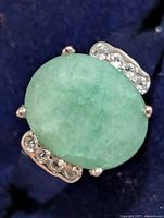 Top view showing oval green dyed emerald topaz and accent stones