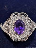 Top view showing oval purple stone and CZ halo