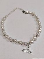 Full view of bracelet showing pearls, silver beads, charm, clasp