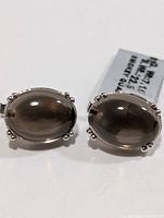 Front view showing both oval smoky quartz cabochon earrings in silver settings