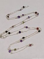 Full view of silver chain necklace with multicolour bezel-set gemstones