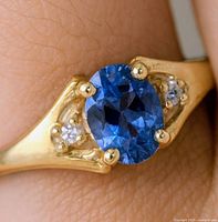 Ring on finger showing tanzanite and diamonds