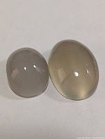 Two oval moonstone cabochons on white background