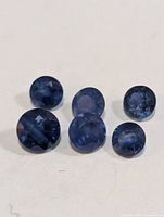 Six blue round-cut sapphires on white background