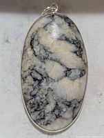 Front view of oval gemstone pendant showing stone pattern and silver bezel