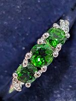 Close-up of chrome diopside stones in silver setting