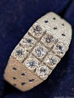 Oblique close-up showing multi-stone setting and textured band