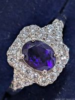Top view of silver ring showing oval purple CZ and clear CZ halo
