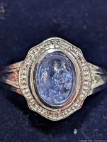 Top view of silver ring showing oval tanzanite and halo