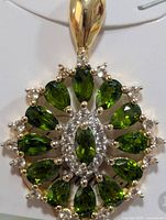 Front view of pendant showing gemstone arrangement and metal tones