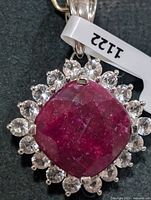 Front view of pendant showing dyed ruby centre and surrounding topaz halo