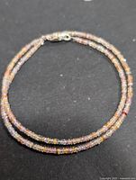 Full view of multicolor sapphire bead necklace coiled