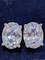Front view of both oval CZ stud earrings set on navy background
