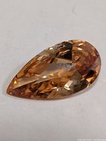 Pear-cut created citrine gemstone, oblique angle view