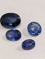 Four oval blue sapphires on light background