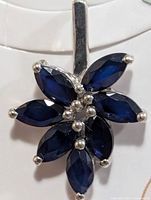 front view of silver pendant with six marquise sapphires