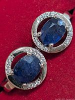 frontal view showing blue stones and clear halo on both earrings