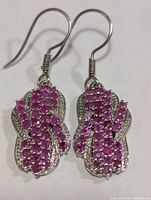 front view of both earrings showing ruby pavé and overall design