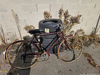 Full left-side view of maroon road bicycle leaning against stacked tires