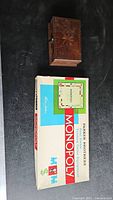 Monopoly board game box and closed wooden cribbage box