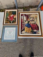All three framed needlepoint pieces on table