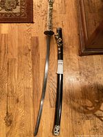 Full view of katana and scabbard on wood floor
