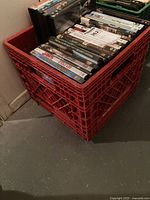 Red milk crate filled with numerous DVD cases