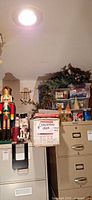 Overall lot on filing cabinets showing large nutcracker, smaller nutcracker, boxed tree, bin of greenery