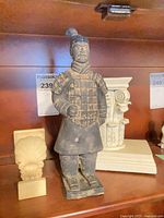 Terracotta warrior figurine, shell corbel, Corinthian capital visible