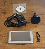 Front view of GPS unit, charger cable, suction mount, adhesive disk and small clip