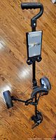 Full view of folded cart standing upright showing handle, scorecard box, wheels