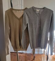 Both cashmere sweaters hanging side by side