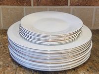 Stack of white plates with gold rims showing quantity and rim detail
