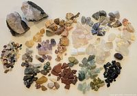 All stones laid out showing quantity and variety with two geode halves at top left