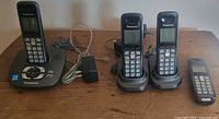 Full lot view showing base station, four handsets, two charging cradles, power adapter and phone cord