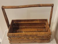 Top angled view of rectangular bamboo/wood caddy showing interior slats and handle