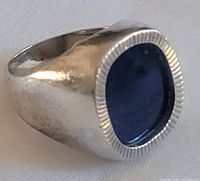 Three-quarter view of ring showing blue cabochon and fluted bezel