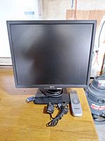 Front view of Acer AL1916 monitor with VGA cable, power cable, Sanyo remote